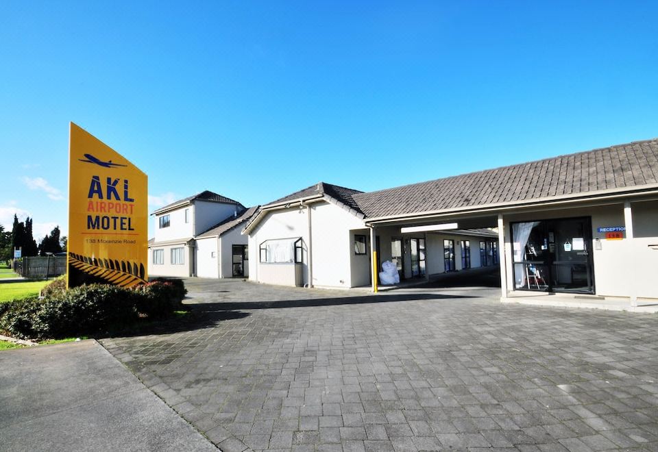 "a hotel with a yellow sign that says "" wakul hotel "" in front of a white building" at Auckland Airport Motel