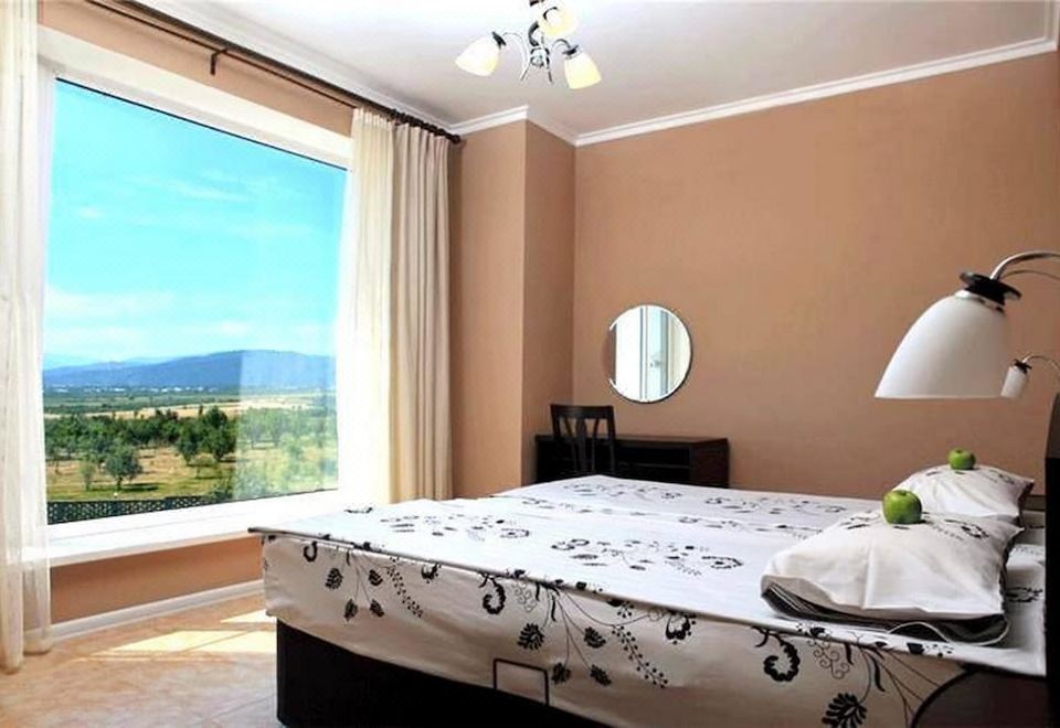 a bedroom with a large bed and a view of the mountains outside the window at Holiday Village
