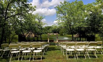 a wedding ceremony taking place outdoors , with rows of white chairs set up for guests at Walnut Waters Bed & Breakfast