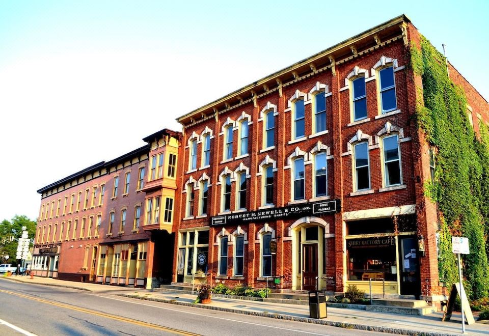 a brick building on a city street , with several cars parked in front of it at Hart House Hotel