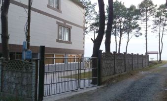 a house with a white fence and a black gate is in the background of a driveway at Villa Eli