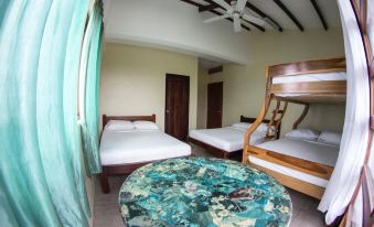 a room with three beds , one of which is a bunk bed , and a dining table at Makai