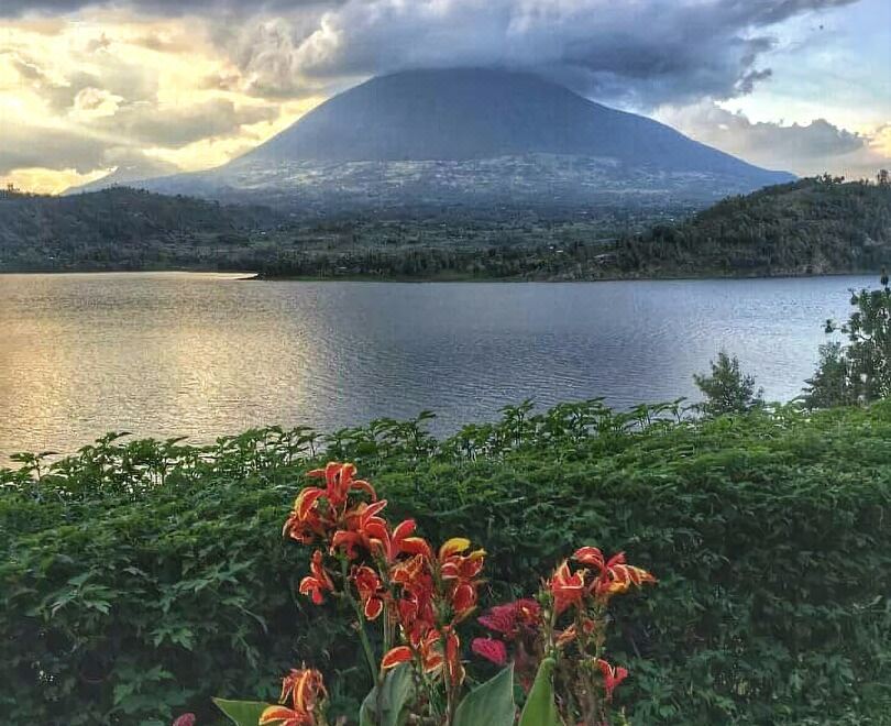 a picturesque landscape with a large mountain , a lake , and a garden filled with vibrant flowers at Twin Lakes Lodge
