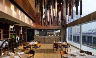 a modern dining room with wooden floors and a unique chandelier hanging from the ceiling at Novotel Bangkok Impact