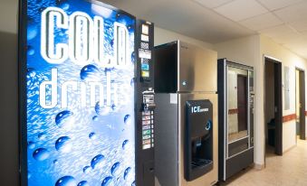 "a vending machine filled with a blue and white sign that says "" cold drink "" is next to other vending machines" at Executive Inn