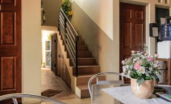 a dining room with a table and chairs , along with a staircase leading to an upper level at My Place Guest House Manado