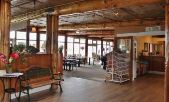 a spacious room with wooden floors and walls , featuring a kitchen area , dining table , and benches at Lopez Islander Resort