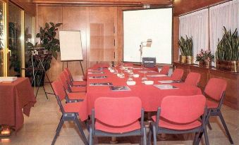 a conference room set up for a meeting , with chairs arranged in a semicircle around a table at Hotel Milano