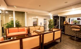 a hotel lobby with various seating options , including couches and chairs , as well as a reception desk at Gold Hotel Hue