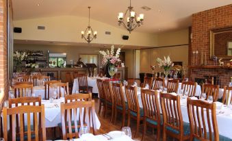 a large dining room with wooden chairs and tables set up for a formal event at Wild Cattle Creek Estate