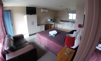 a small , well - furnished living room with a couch and a dining table in the background at All Seasons Holiday Park