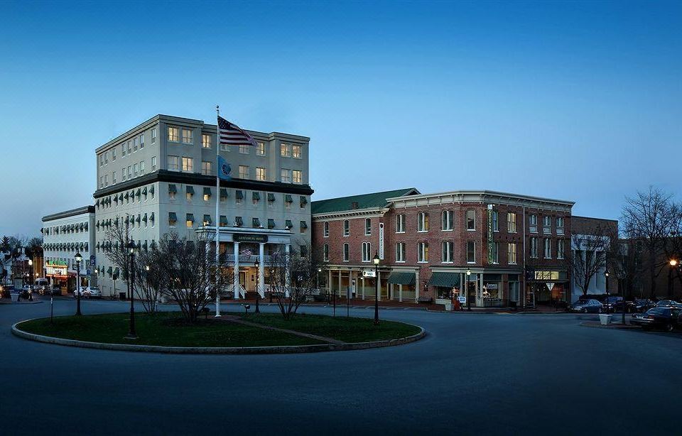 a large building with a flag on top is next to a smaller one with buildings in front at Gettysburg Hotel