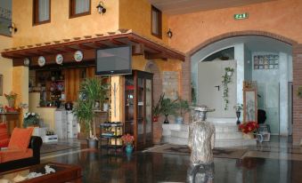 a hotel lobby with a large screen tv mounted on the wall and potted plants at Hotel Esperia