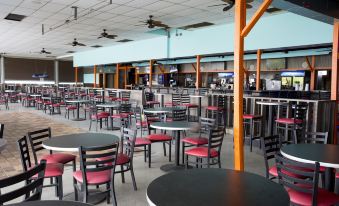 a large dining area with multiple tables and chairs , as well as a bar in the background at Indiana Beach Accommodations
