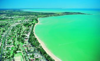 aerial view of a large body of water , possibly a lake , with a sandy beach surrounded by lush green grass at Akama Resort