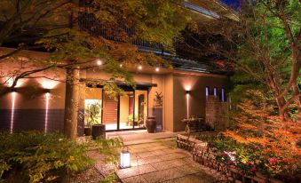 a well - lit building with trees and plants , creating a serene and inviting atmosphere at night at Miyako