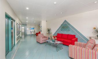 a modern living room with red couches , blue and white striped chairs , and a large triangular wall at Argyle on the Park