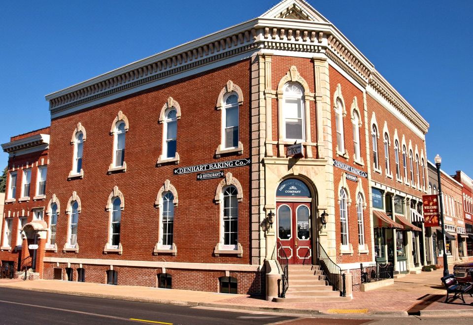 a brick building with a red brick facade and a blue door is situated on a street corner at Cornerstone Inn