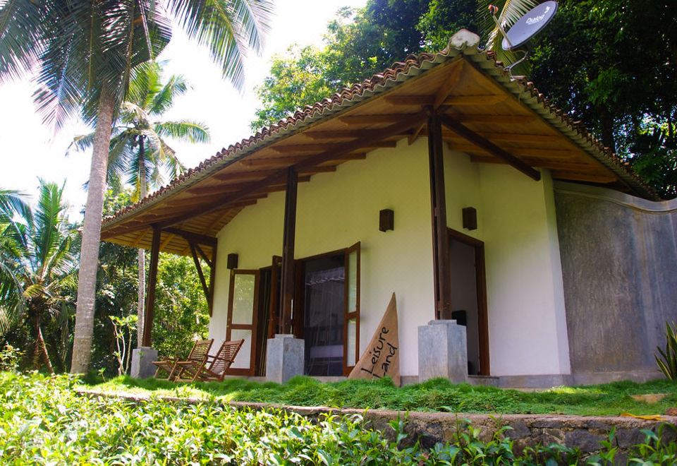 There is a small house in a rural area with a view of the outside and a front door that leads to another room at Leisure Land