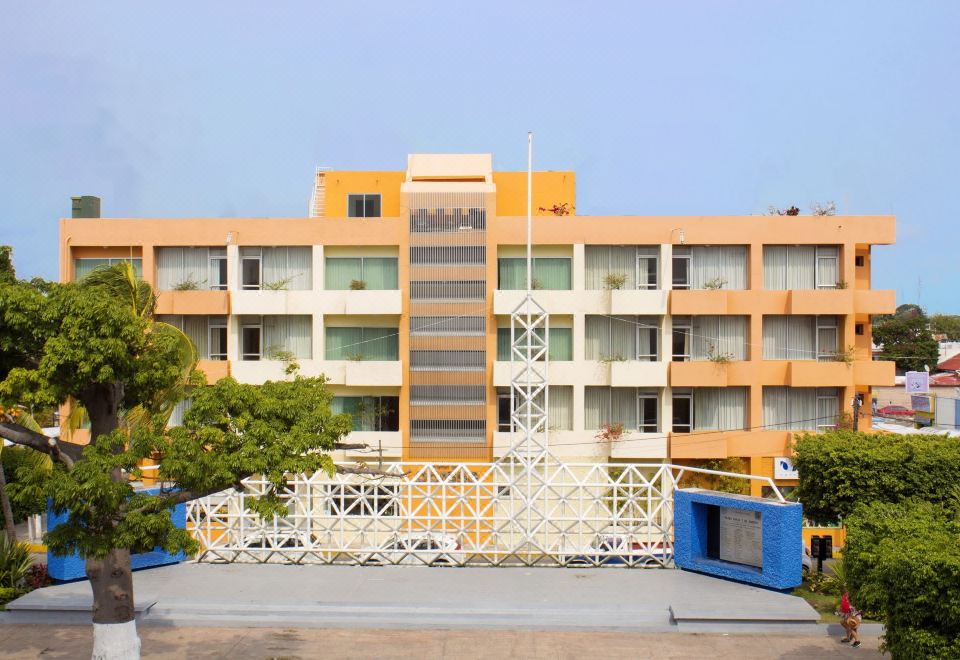 a large , modern apartment building with multiple balconies and windows , situated in front of a clear blue sky at Hotel del Parque