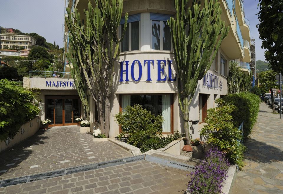 "a building with the word "" hotel "" written on it , surrounded by trees and other buildings" at Hotel Majestic