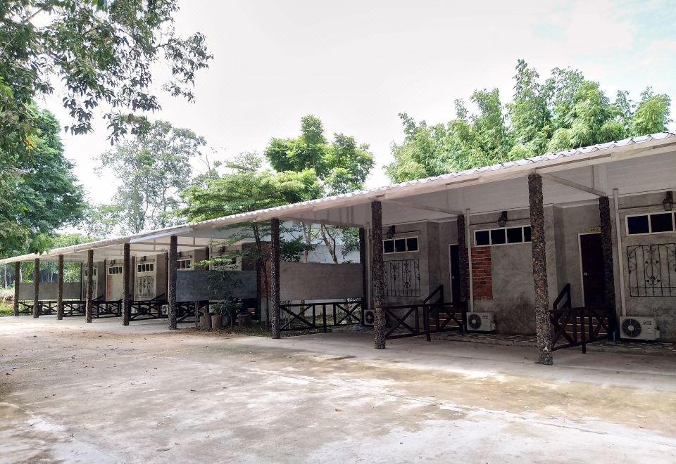 a long building with a covered area and several smaller ones in front of it at Chanthaburi Garden Hotel