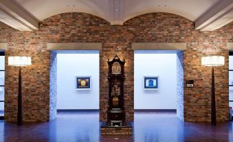 a large , empty room with a brick wall and two white walls , featuring a clock in the center at La Vista Hakodate Bay