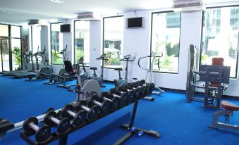 a well - equipped gym with various exercise equipment , including weights , a treadmill , and a stationary bike at Chon Inter Hotel