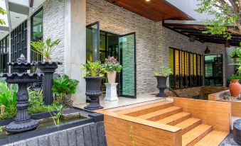 a modern house with a large wooden deck and multiple potted plants in front of it at Soho Boutique Hotel