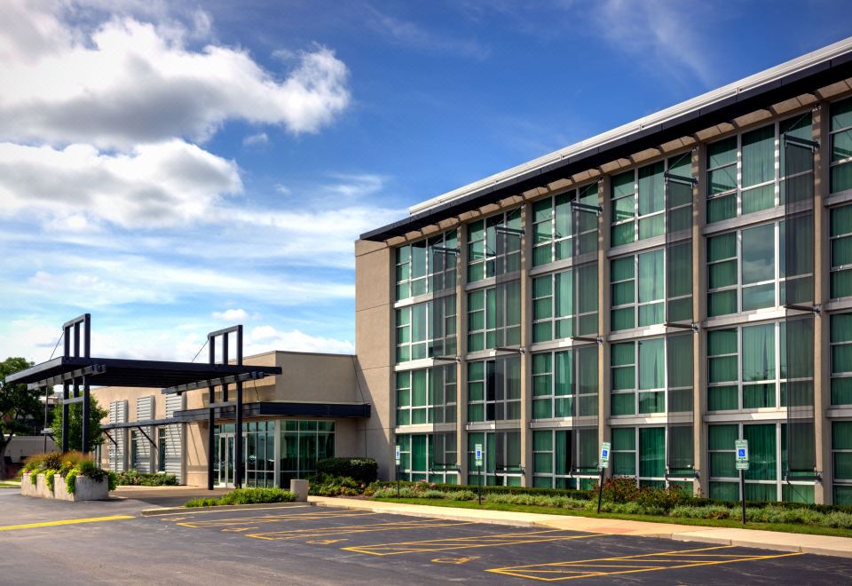 a modern office building with large glass windows and a parking lot in front of it at Crowne Plaza Lombard Downers Grove
