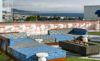 a rooftop lounge area with multiple couches and chairs , providing a comfortable space for relaxation and socializing at Hotel Hermosa