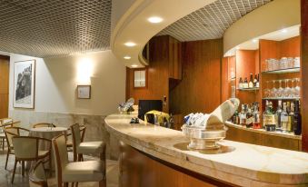 a modern bar with a marble counter and chairs , featuring a variety of bottles and glasses at Best Western Park Hotel