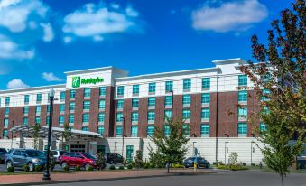 a large hotel with a green and white sign on the side of the building at Holiday Inn Owensboro Riverfront