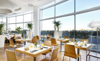 a large dining room with several tables and chairs arranged for a group of people to enjoy a meal at Hotel Diamante