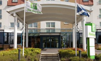 the entrance to a holiday inn hotel with two flags on either side of the building at Holiday Inn Aberdeen - West