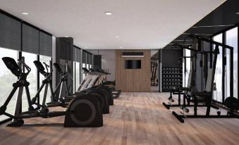 a gym with various exercise equipment , including treadmills and weightlifting machines , in a spacious room at Fortune Hotel Buriram