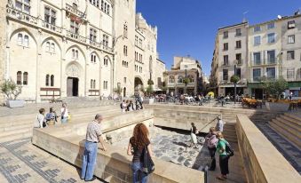 a group of people standing in front of a building , with some of them looking at the water feature at Marina