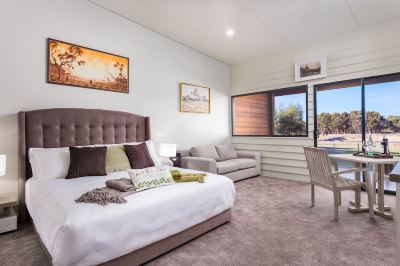 a bedroom with a bed , couch , and sliding glass doors leading to a pool area at The Swan Valley Retreat