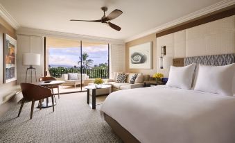 a modern hotel room with a large bed , couch , and sliding glass doors leading to a balcony at Four Seasons Resort Maui at Wailea