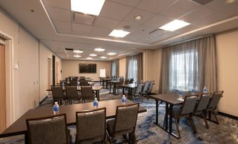 a large , empty conference room with multiple tables and chairs arranged for a meeting or event at Fairfield by Marriott Edmonton International Airport