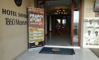 "a doorway with a sign for "" prawn express "" and a rug on the floor , leading into a hotel" at Hotel Savera