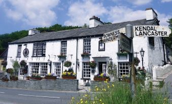 "the bowness wyndery inn is a white building with a sign that says "" bowness wyden ""." at The Brown Horse Inn