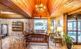 a cozy wooden interior with a large window , bookshelves , and furniture , all lit by hanging lights at Crystal Coast Oceanfront Hotel