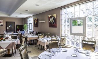 a large dining room with multiple tables and chairs arranged for a group of people to enjoy a meal together at Mercure Castres l'Occitan