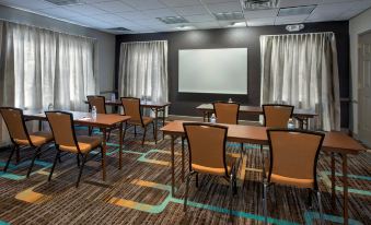 a conference room with rows of chairs arranged in a semicircle , and a projector on the wall at Residence Inn Cranbury South Brunswick