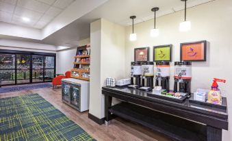 a hotel lobby with a long counter and several coffee machines , creating a coffee shop atmosphere at Grayson Manor