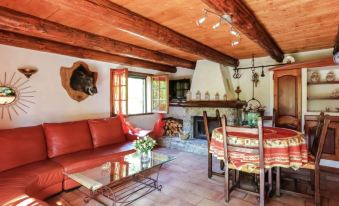 a cozy living room with a red couch , dining table , and wooden beams on the ceiling at Andon