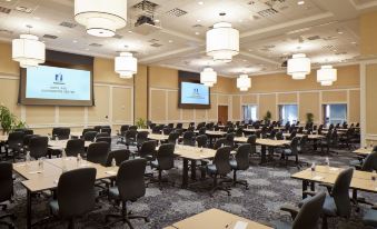 a large conference room with multiple rows of tables and chairs , surrounded by multiple screens on the walls at Nationwide Hotel and Conference Center