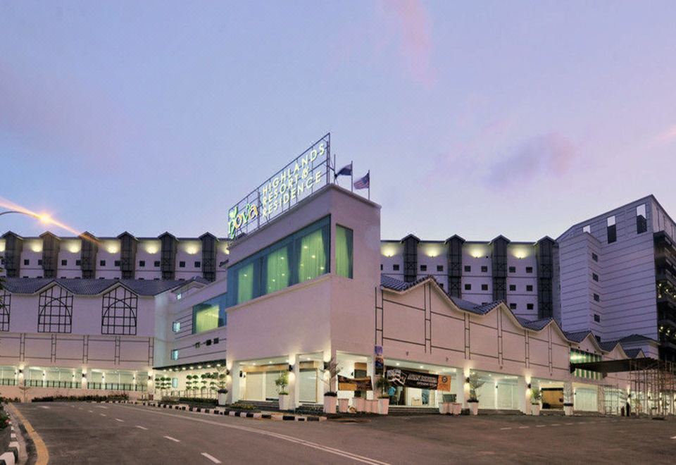 "a large building with a green and white sign that reads "" jcube "" is shown at dusk" at Nova Highlands Hotel