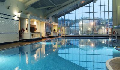 an indoor swimming pool with a glass roof , allowing natural light to fill the space at Village Hotel Liverpool